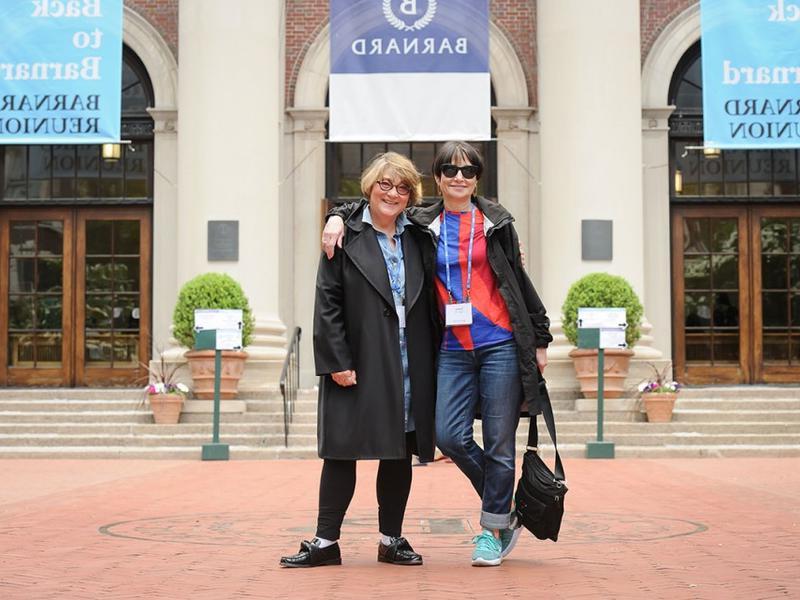 2 women, one arm around the other's shoulders, on Barnard's campus